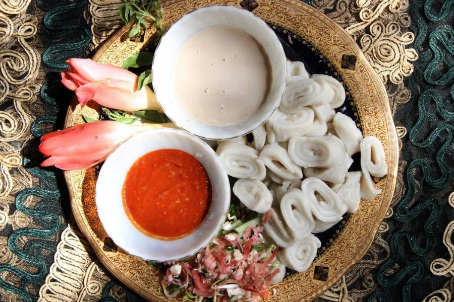 Laksam menggunakan mi beras leper yang digulung dan disajikan bersama kuah pekat berlemak.