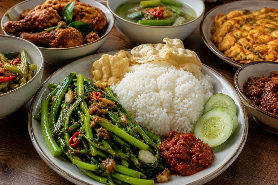 Hidangan nasi putih bersama lauk masakan Melayu tidak lengkap tanpa juadah kangkung tumis belacan.