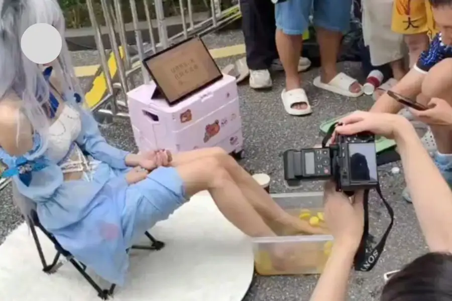 Peserta cosplay merendam kaki di dalam air bercampur hirisan lemon sebelum dijual sebagai minuman.