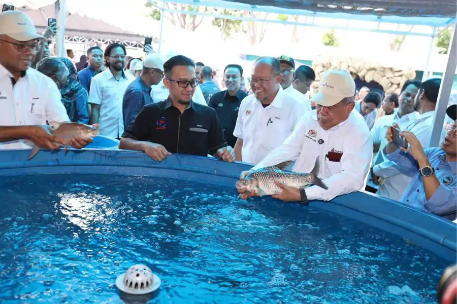 Datuk Seri Mohamad Sabu melepaskan ikan ke dalam kolam ketika melawat lokasi tarikan MAHA di Maeps, Serdang.